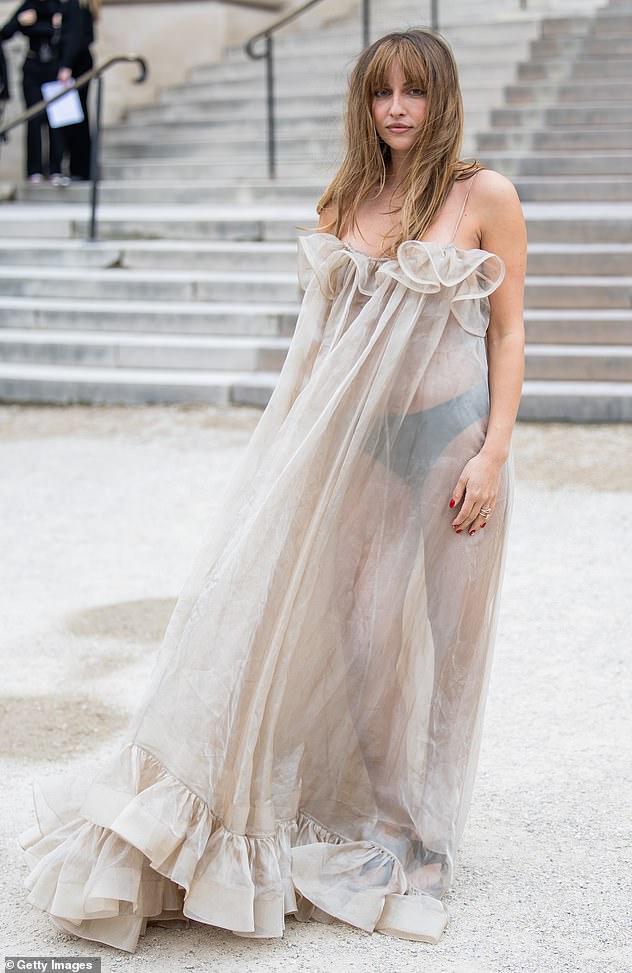 Nepo baby flashes her underwear in a flowing semi-sheer gown during Paris Fashion Week - but can YOU guess who her famous father is?